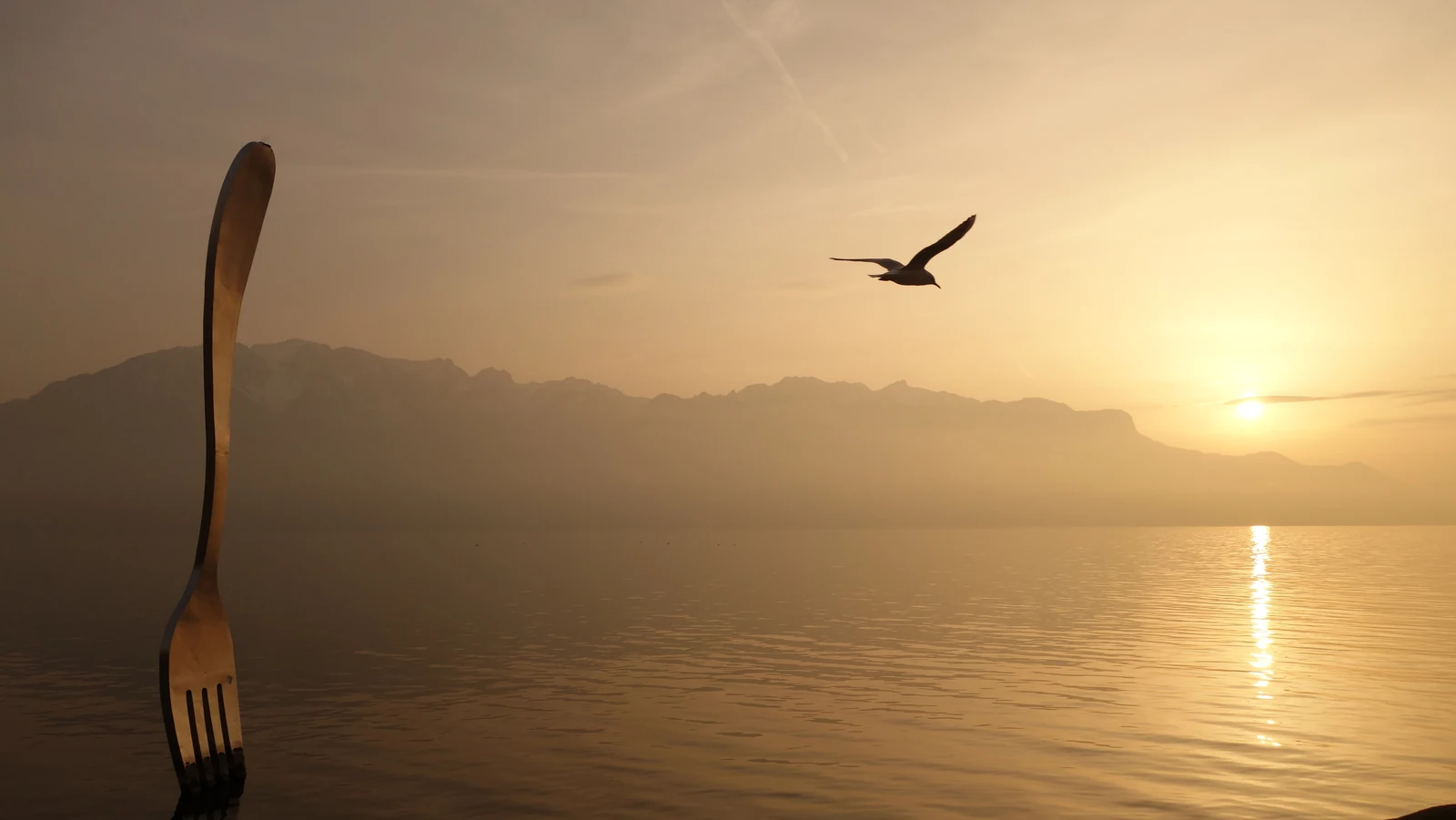 La Fourchette de Vevey devant le Léman et les montagnes, dans la lumière dorée du soleil couchant.